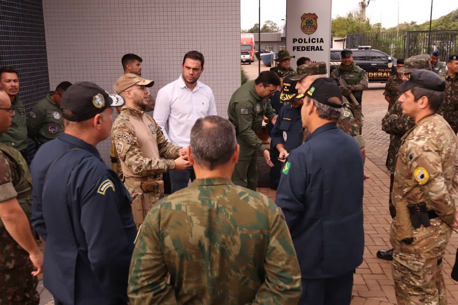 Agentes da Polícia Federal e militares reunidos em frente a unidade da Polícia Federal durante operação de fronteira