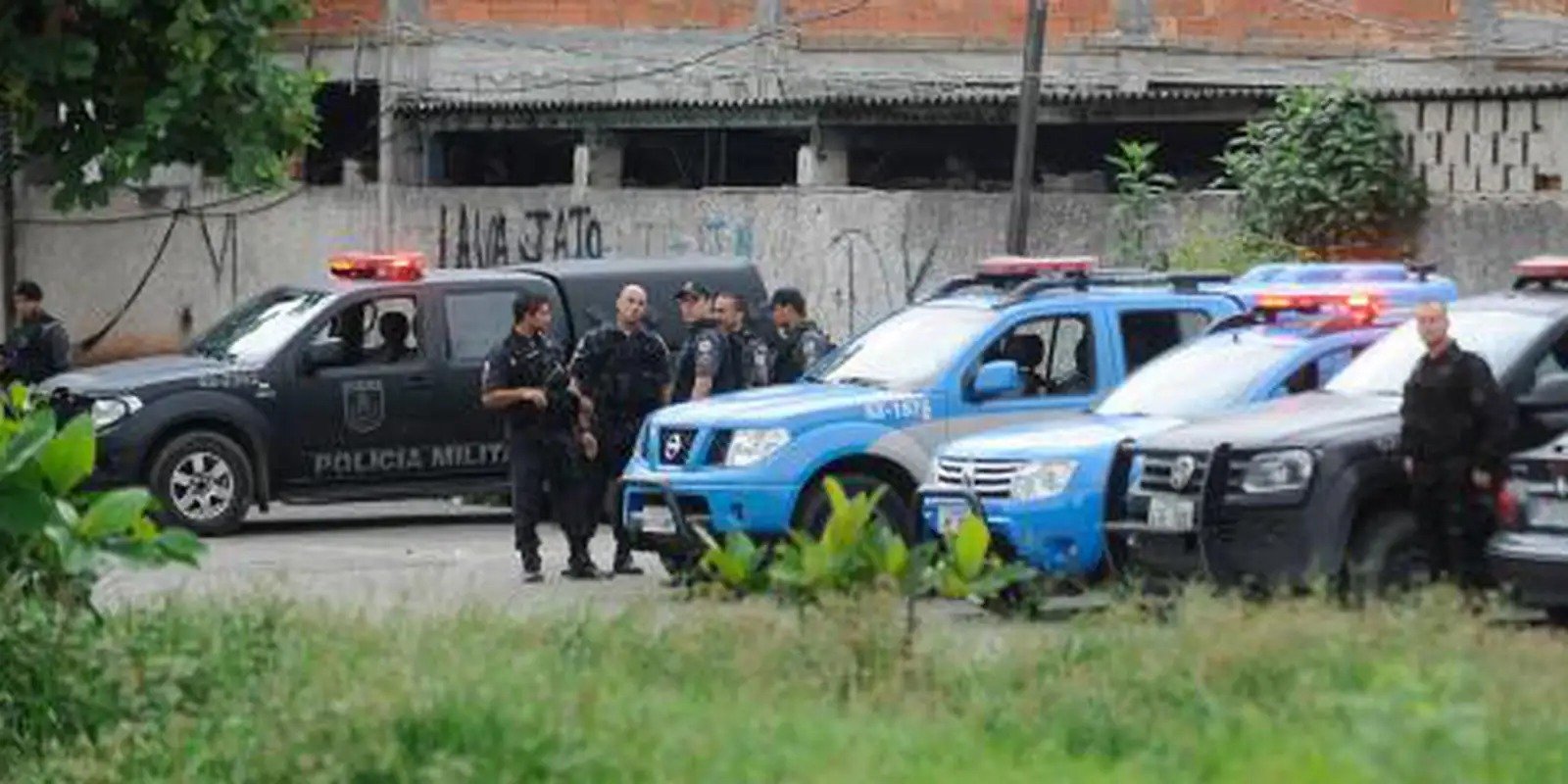 Viaturas e policiais militares em operação em via urbana