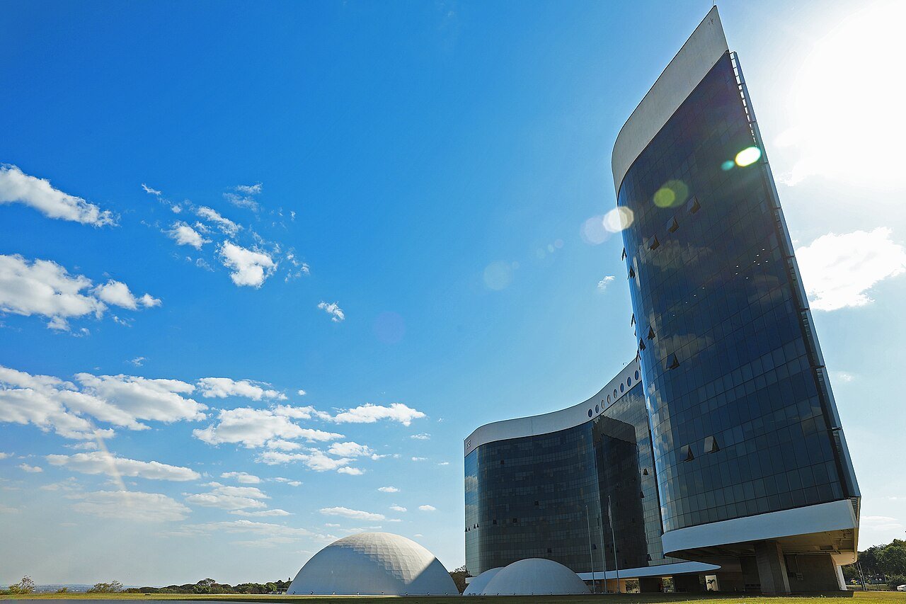 Fachada de vidro do edifício-sede do Tribunal Superior Eleitoral em Brasília sob céu azul