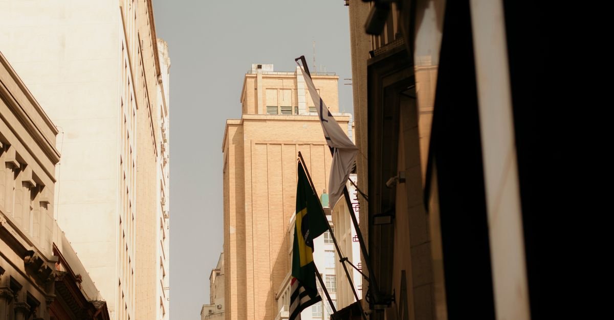 Bandeiras do Brasil e de São Paulo hasteadas em fachadas de prédios no centro da capital paulista