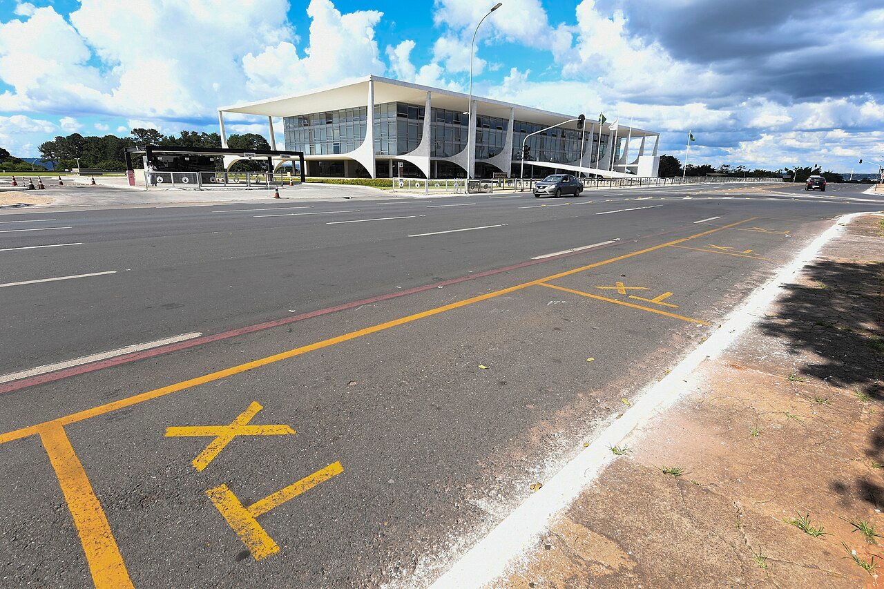 Fachada do Palácio do Planalto vista da via em frente, com a bandeira do Brasil hasteada