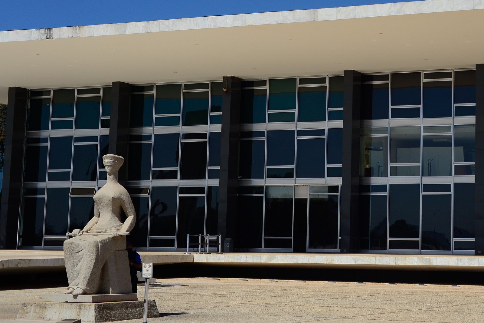 Fachada do edificio-sede do STF na Praca dos Tres Poderes com a estatua A Justica em primeiro plano