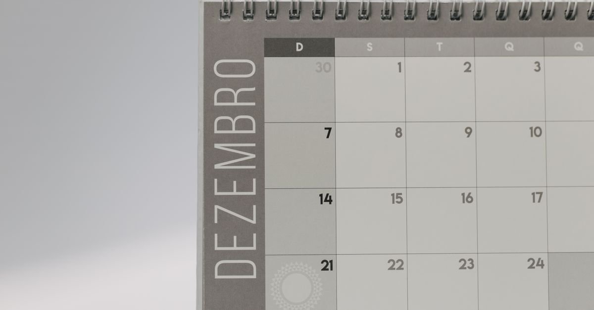 Calendário de mesa com espiral aberto no mês de dezembro, com os dias em destaque