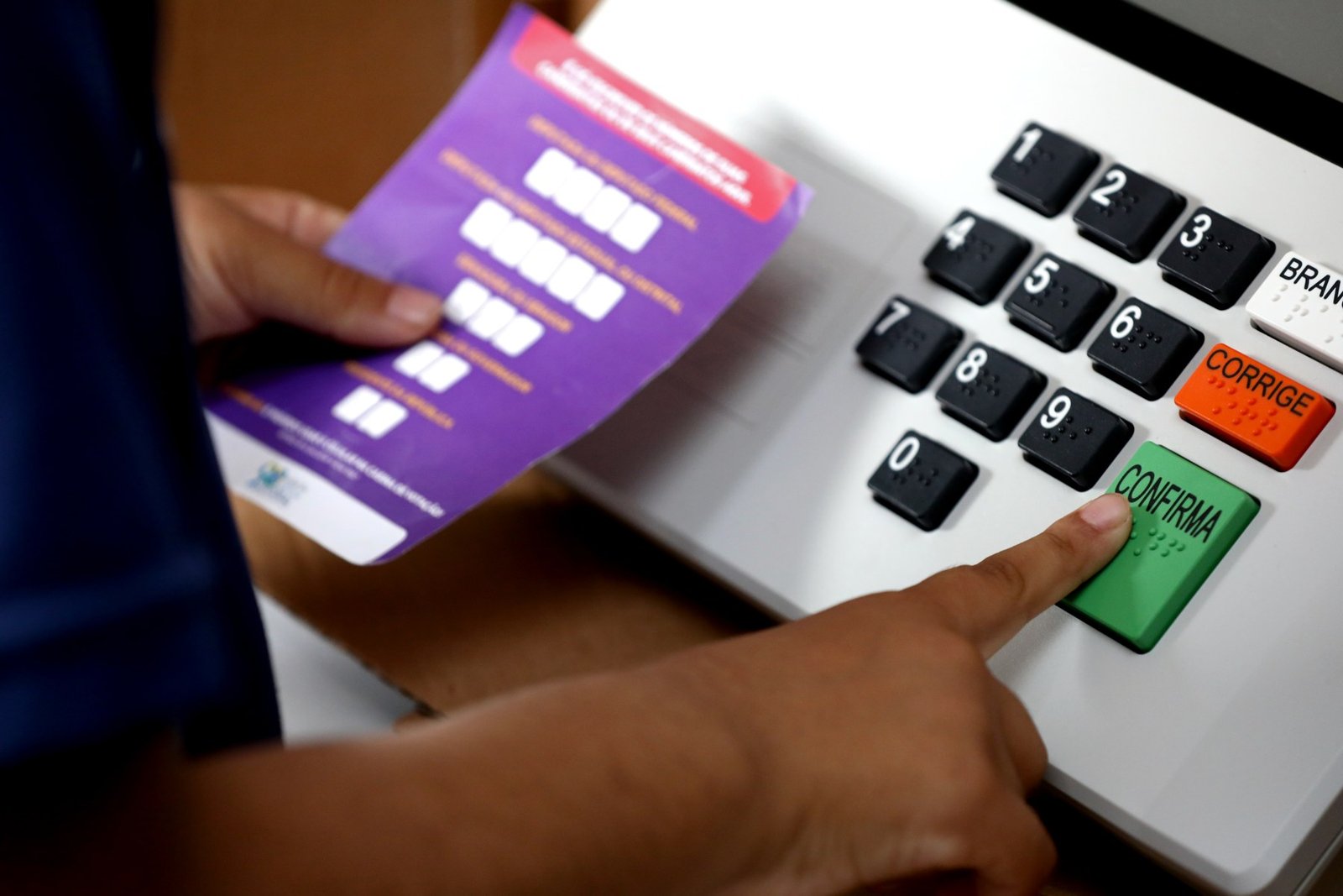 Eleitor aperta a tecla confirma em urna eletrônica durante demonstração do TSE