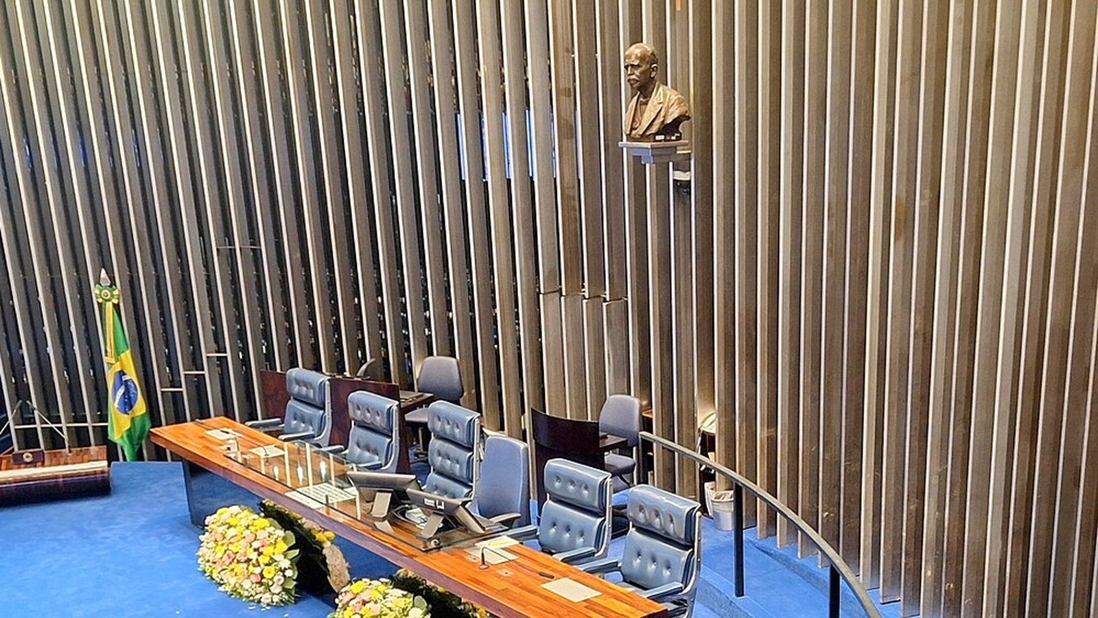 Mesa do plenário do Senado Federal, com a bandeira do Brasil ao lado das cadeiras