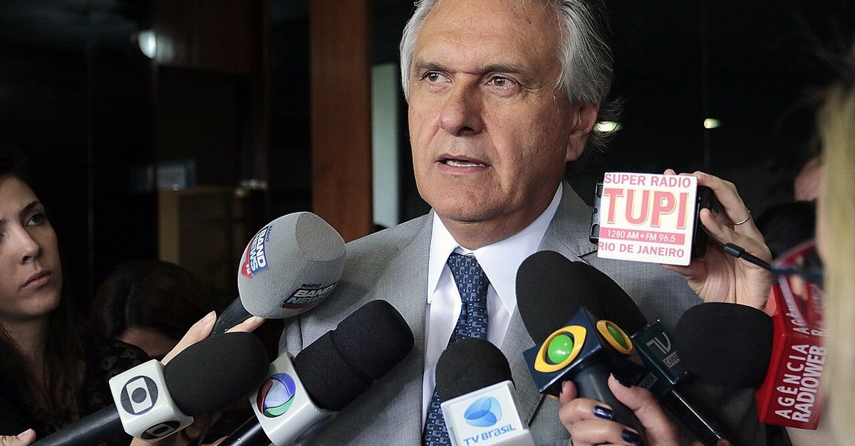 Ronaldo Caiado fala a jornalistas cercado por microfones de emissoras de rádio e televisão