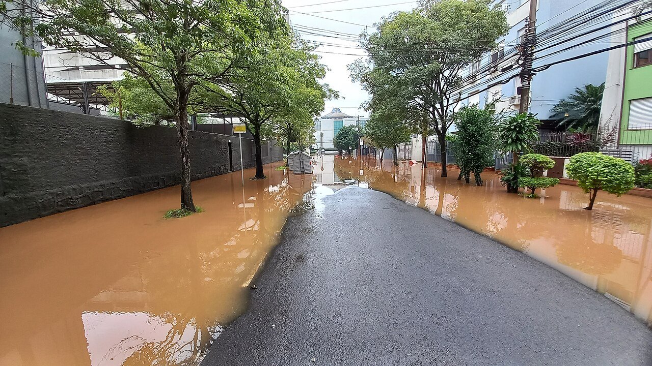 Rua residencial tomada por água barrenta durante enchente em Porto Alegre, no Rio Grande do Sul