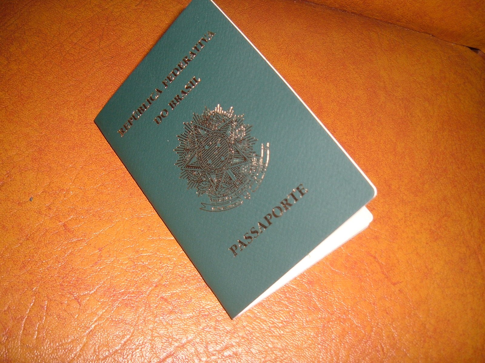 Passaporte da República Federativa do Brasil fechado sobre superfície de couro