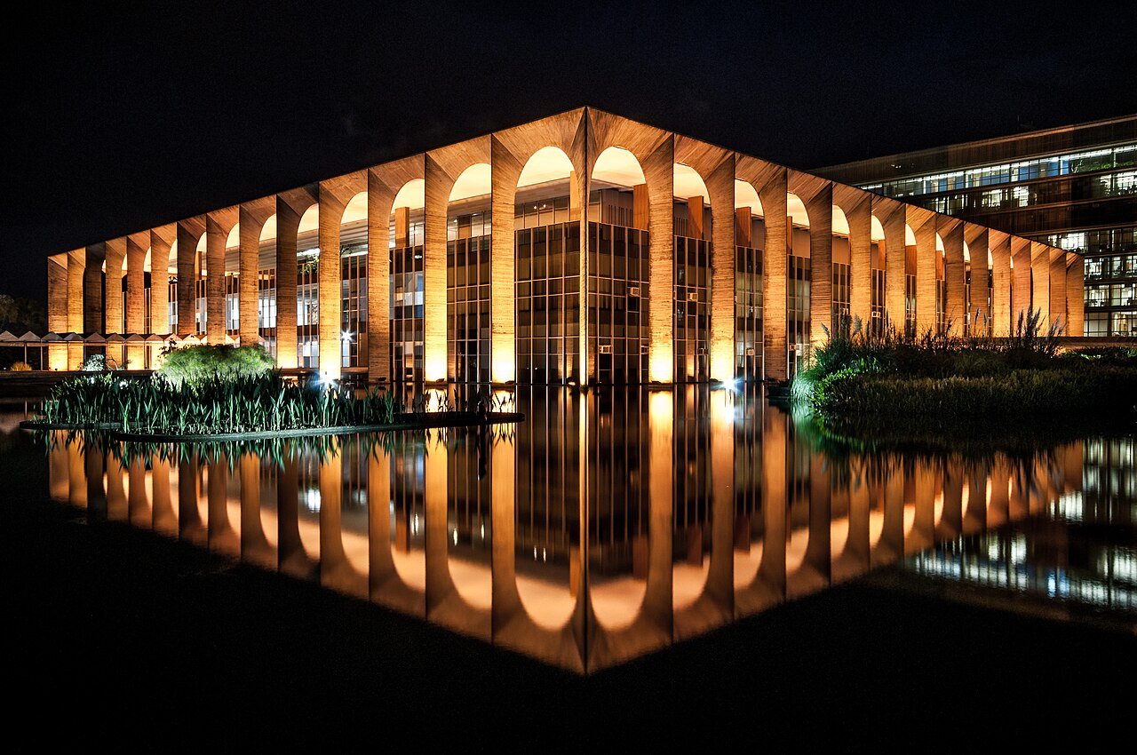 Palácio do Itamaraty iluminado à noite, refletido no espelho d'água