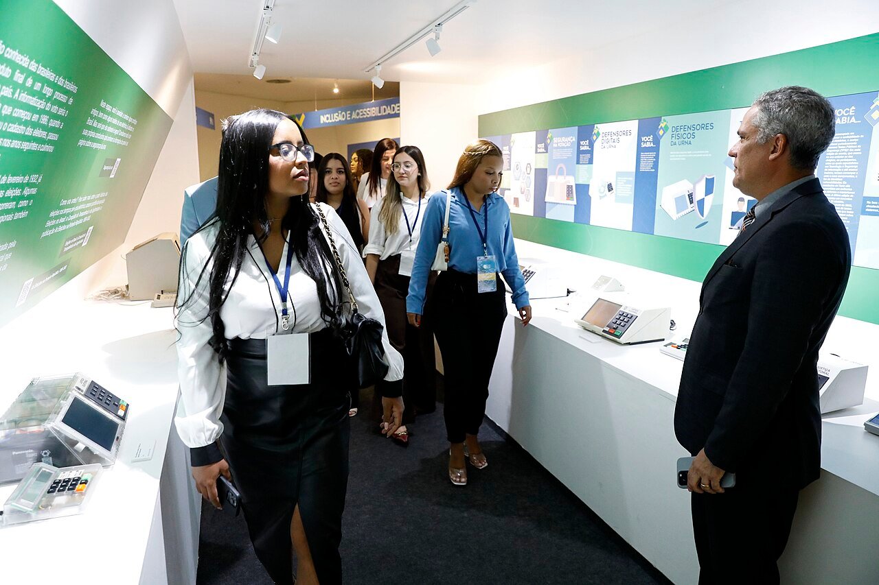 Visitantes observam urnas eletrônicas em exposição na sede do Tribunal Superior Eleitoral