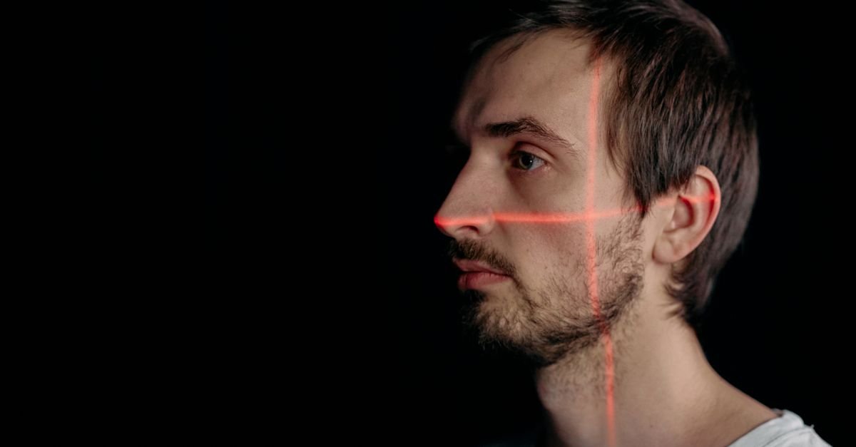 Rosto de homem de perfil marcado por linhas de laser de reconhecimento facial