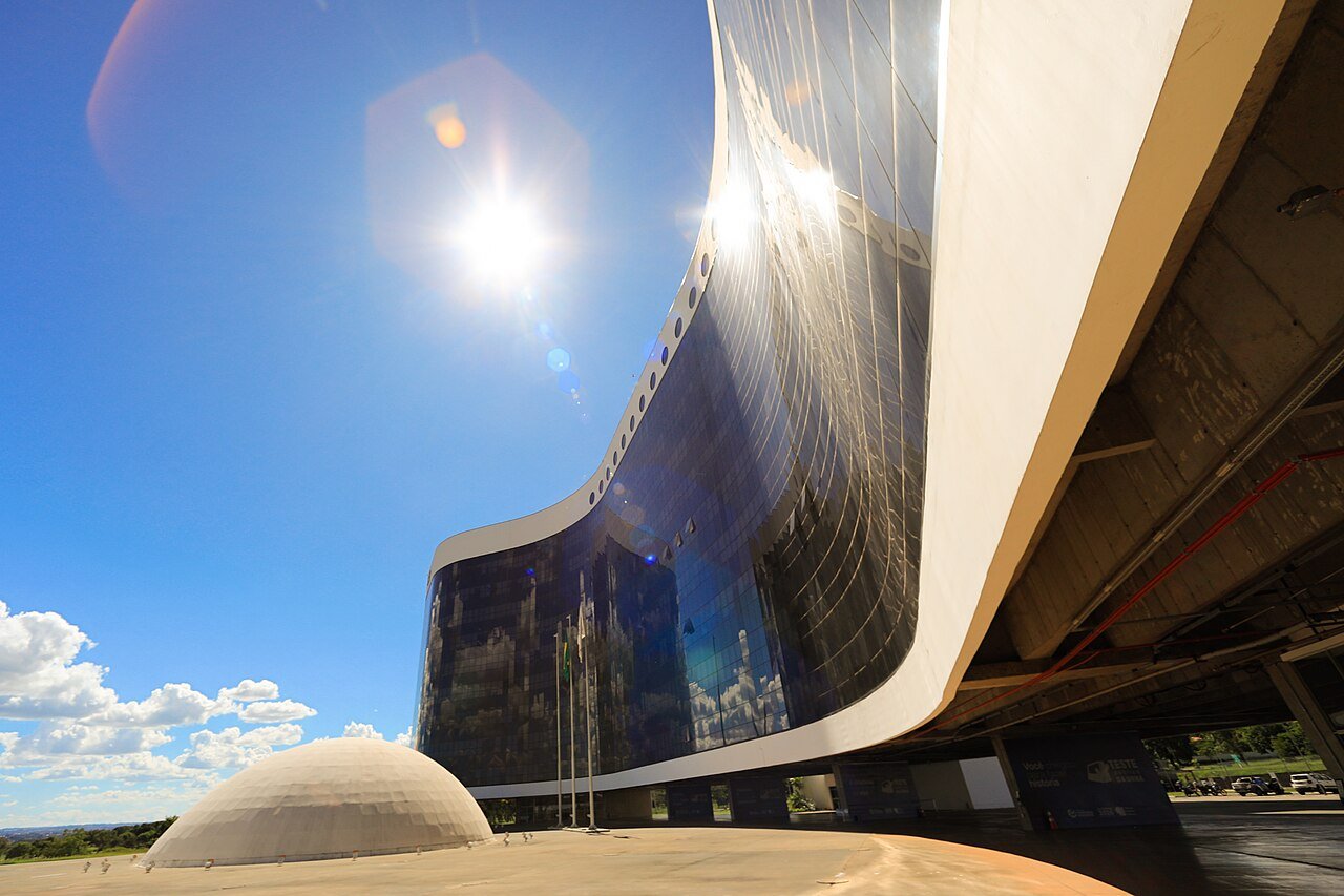 Fachada de vidro curva da sede do Tribunal Superior Eleitoral, em Brasilia, vista de baixo