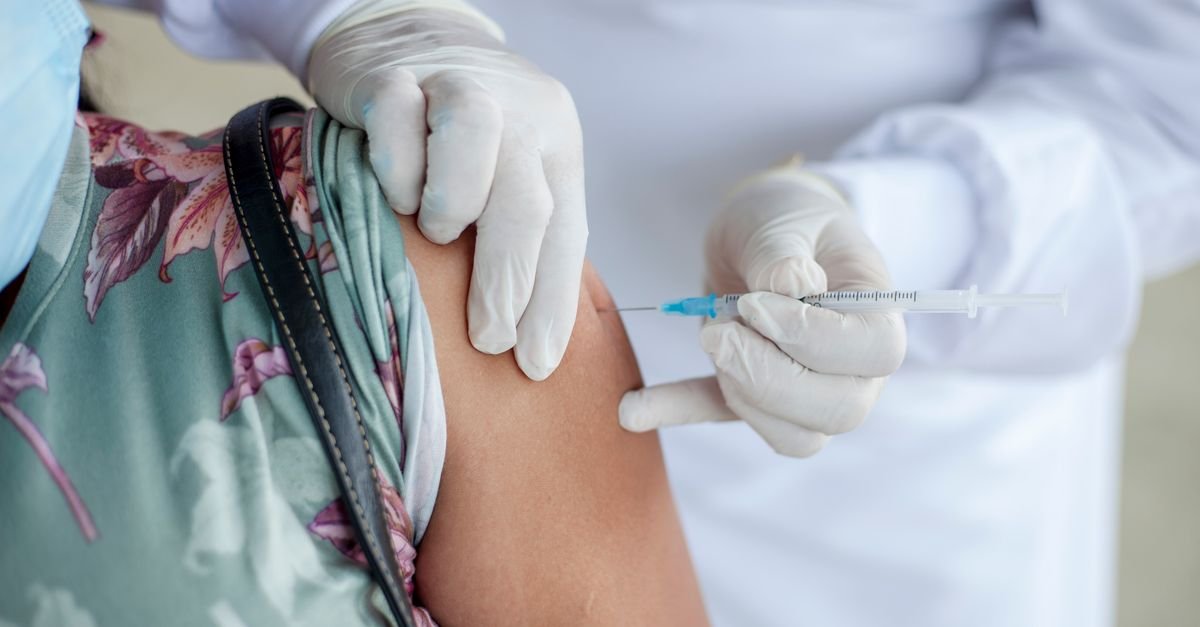 Profissional de saúde aplica vacina no braço de paciente