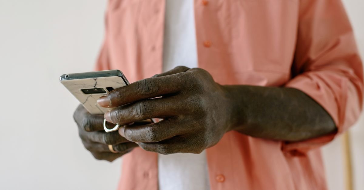 Mãos de uma pessoa segurando um celular durante consulta em aplicativo